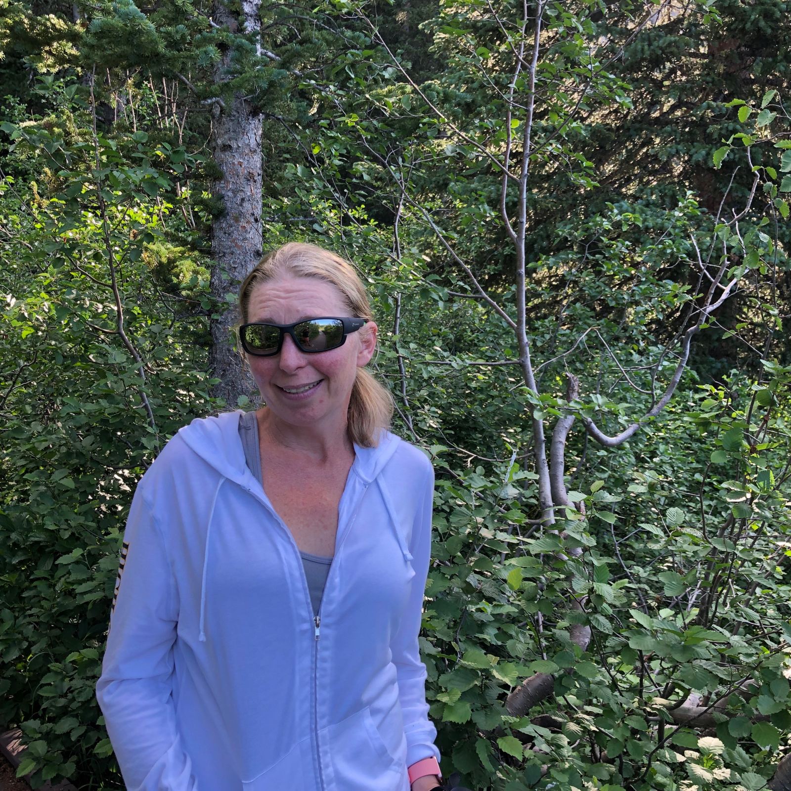 Melissa smiling on a wooded trail